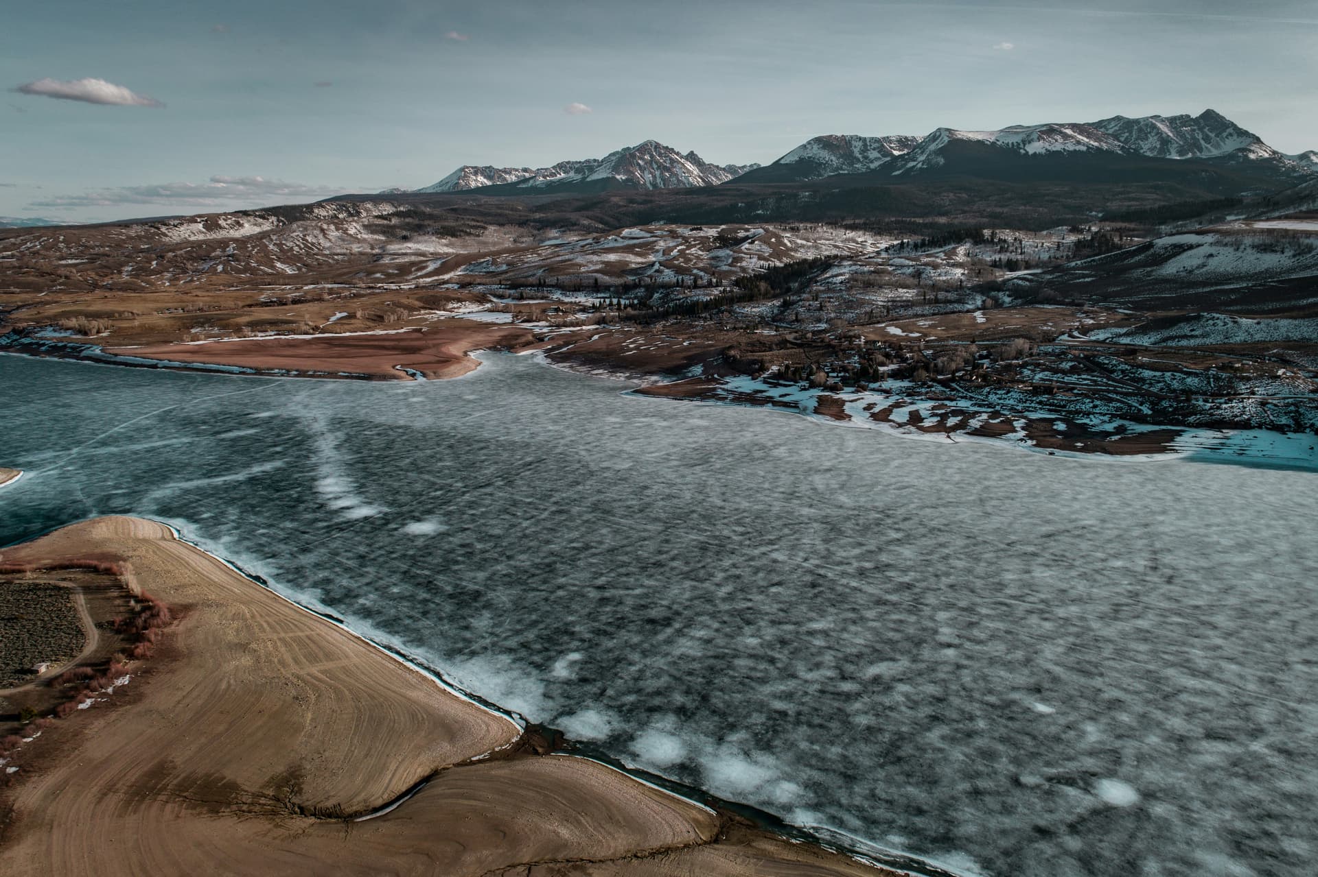 Aerial view of an icy reservoir shoreline and snow-dusted peaks at Silverthorne