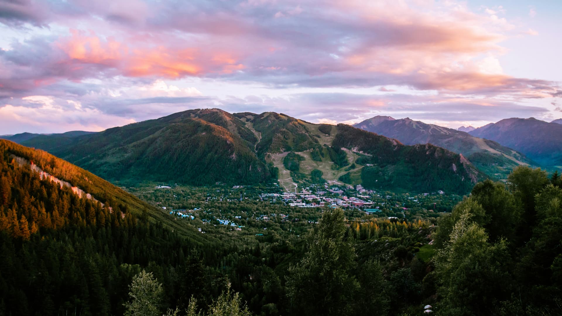 Aspen town at the foot of Aspen Mountain under a pink sunset sky