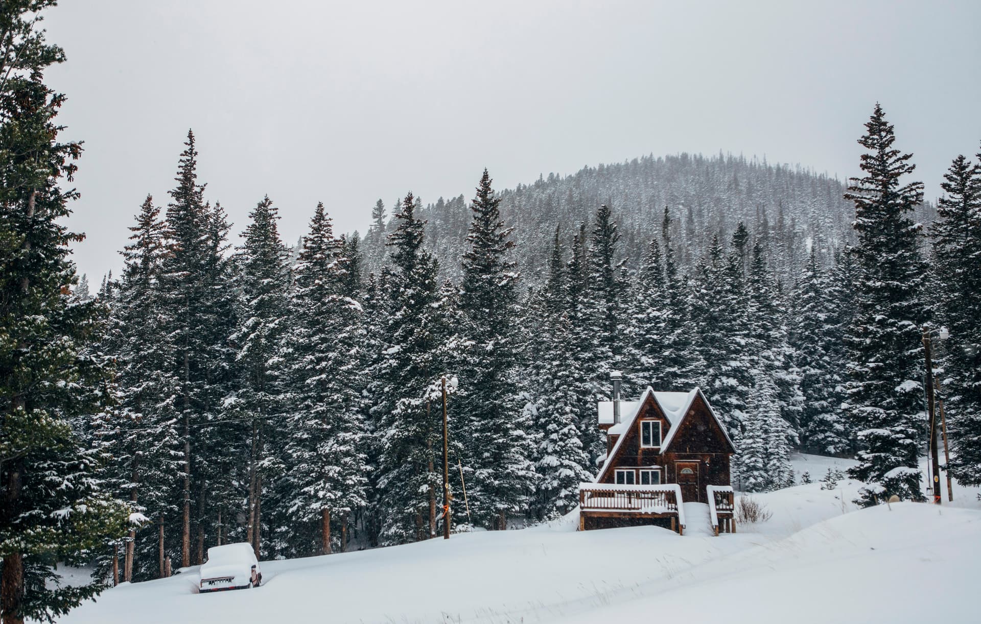 A-frame cabin in a snowy Colorado pine forest