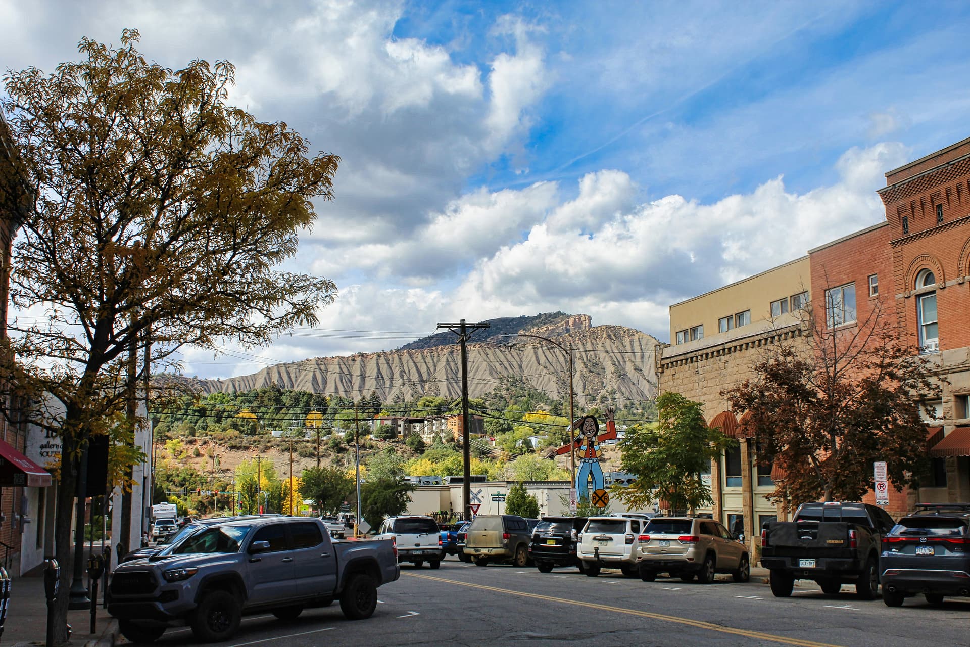 Historic brick storefronts on Durango's Main Avenue with mesa cliffs behind